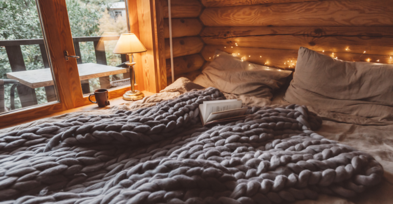 cozy grey bedding inside of a wooden lodge