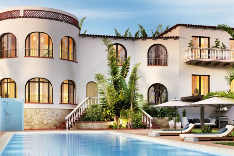 backside view of a stucco villa in a tropical setting with a private pool