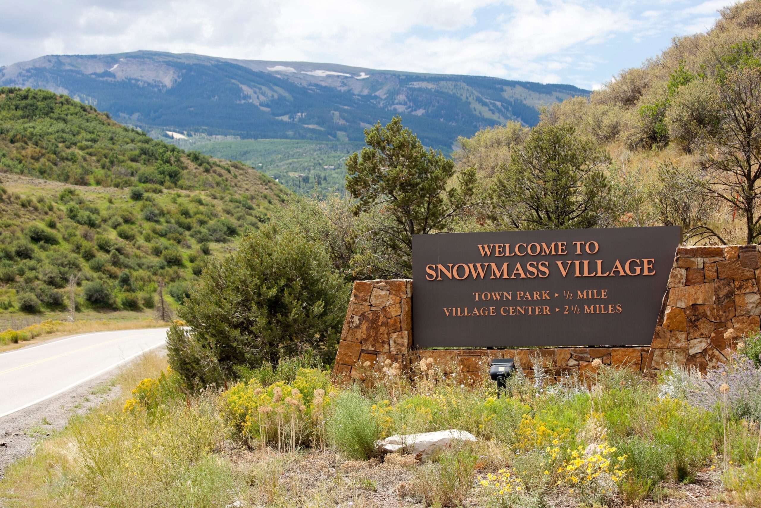 large roadside sign that reads "welcome to Snowmass Colorado"
