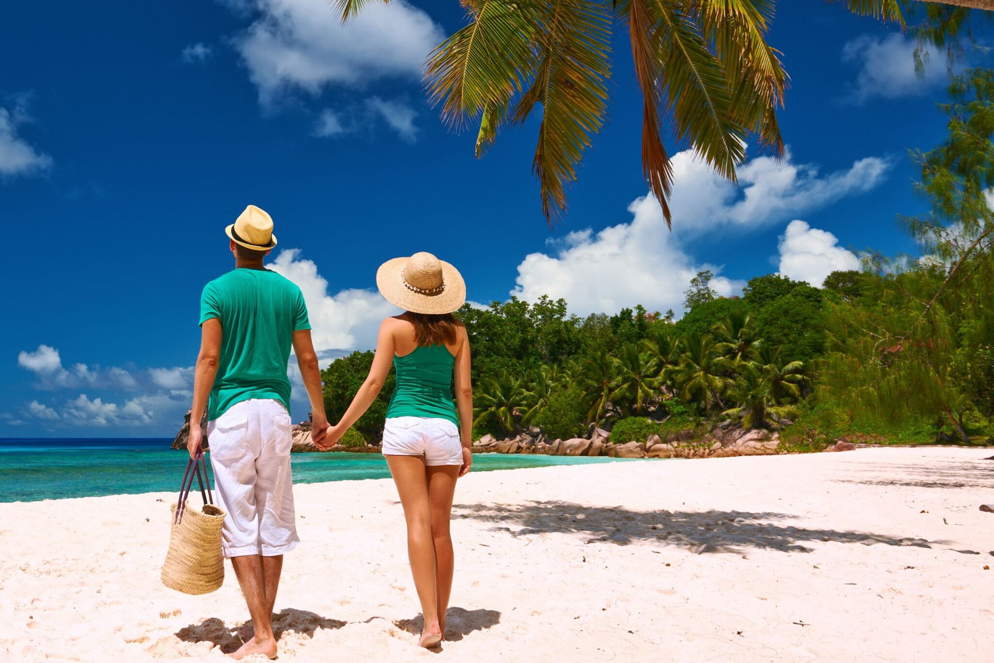 a couple holding hands taking in the view of mauna kea beach