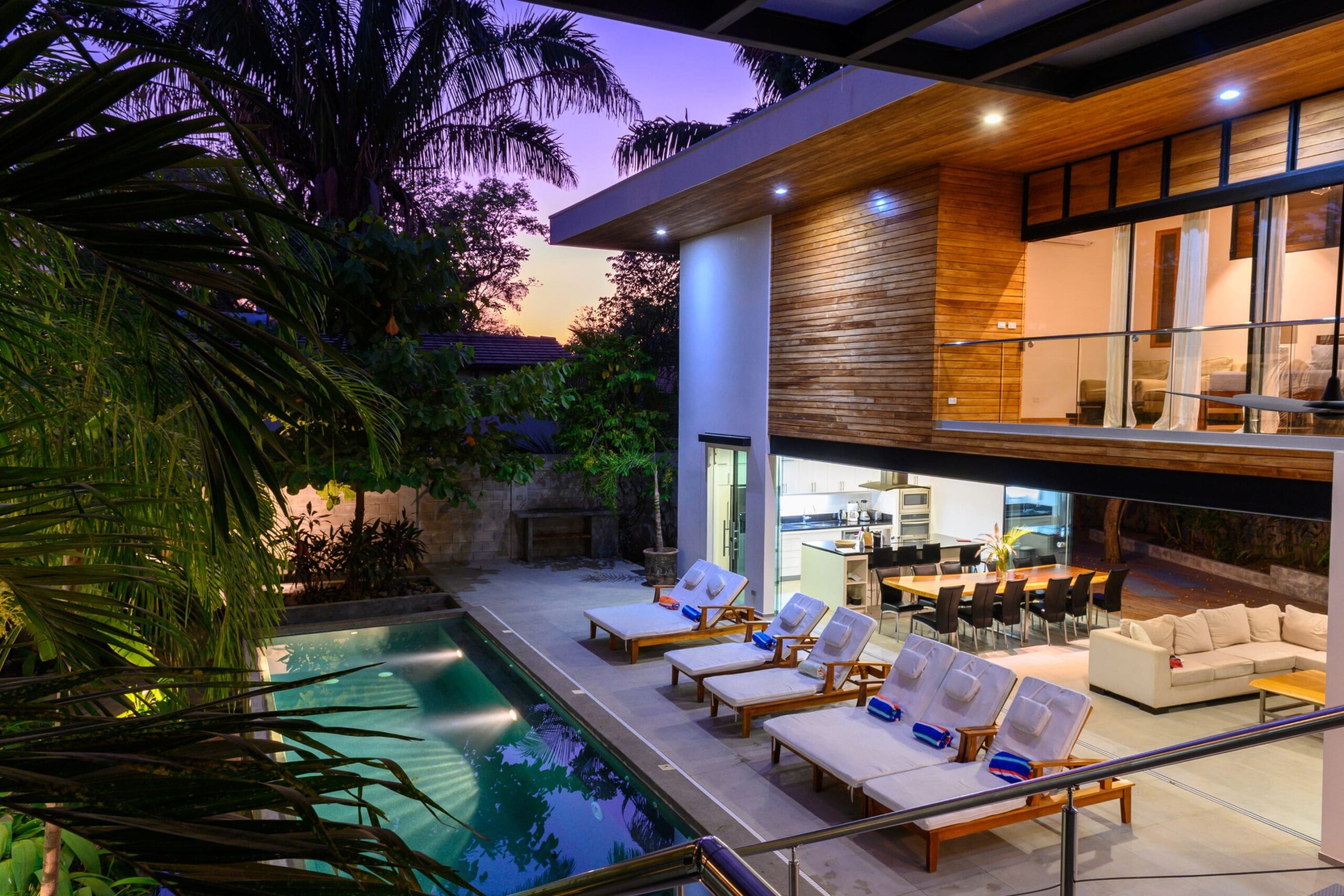 a luxury vacation rental home with lounge chairs and an outdoor pool