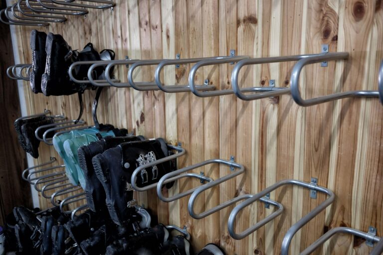 portion of a ski room featuring a rack to hang dry wet boots