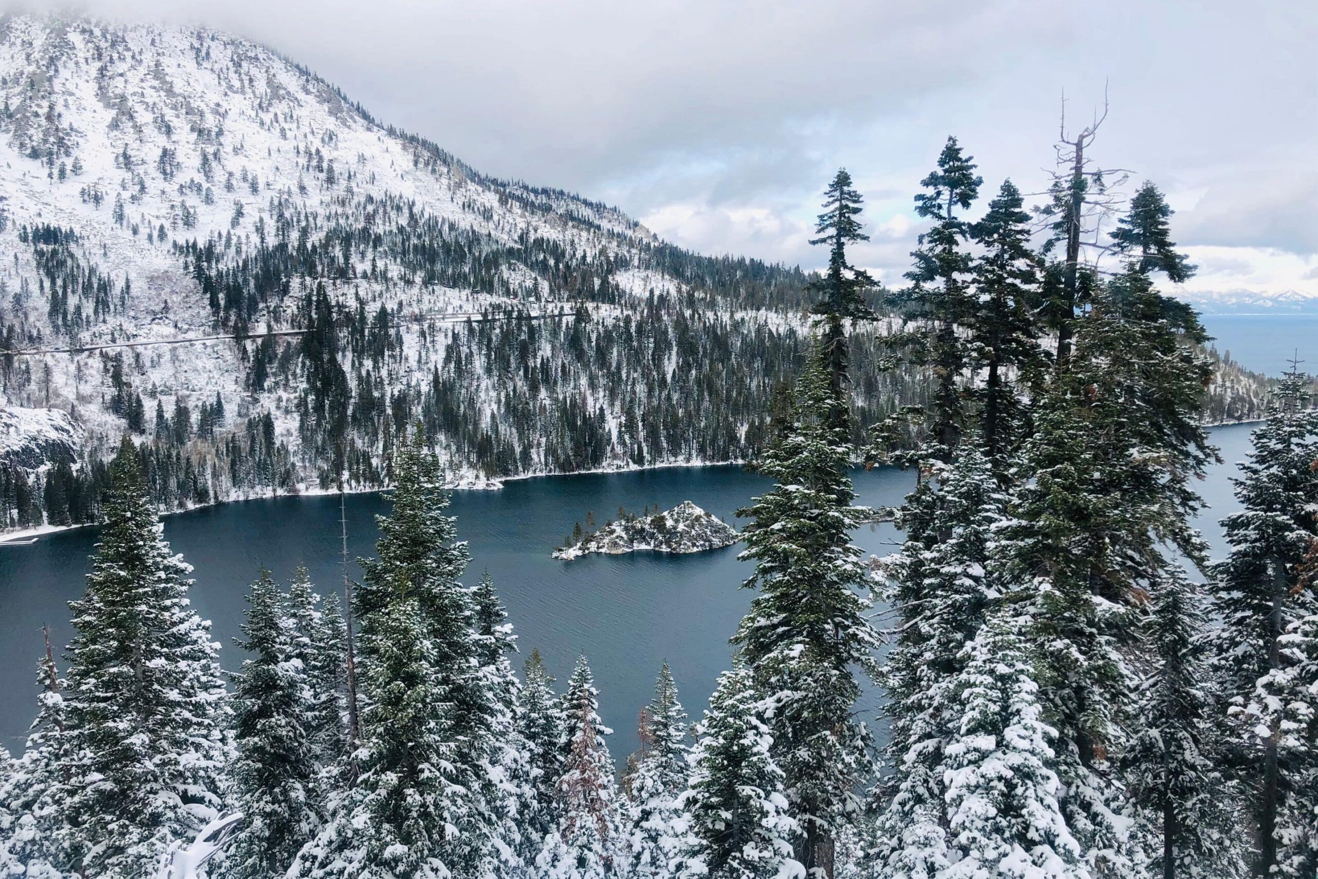 Lake Tahoe surrounded by evergreens and mountains dusted in snow