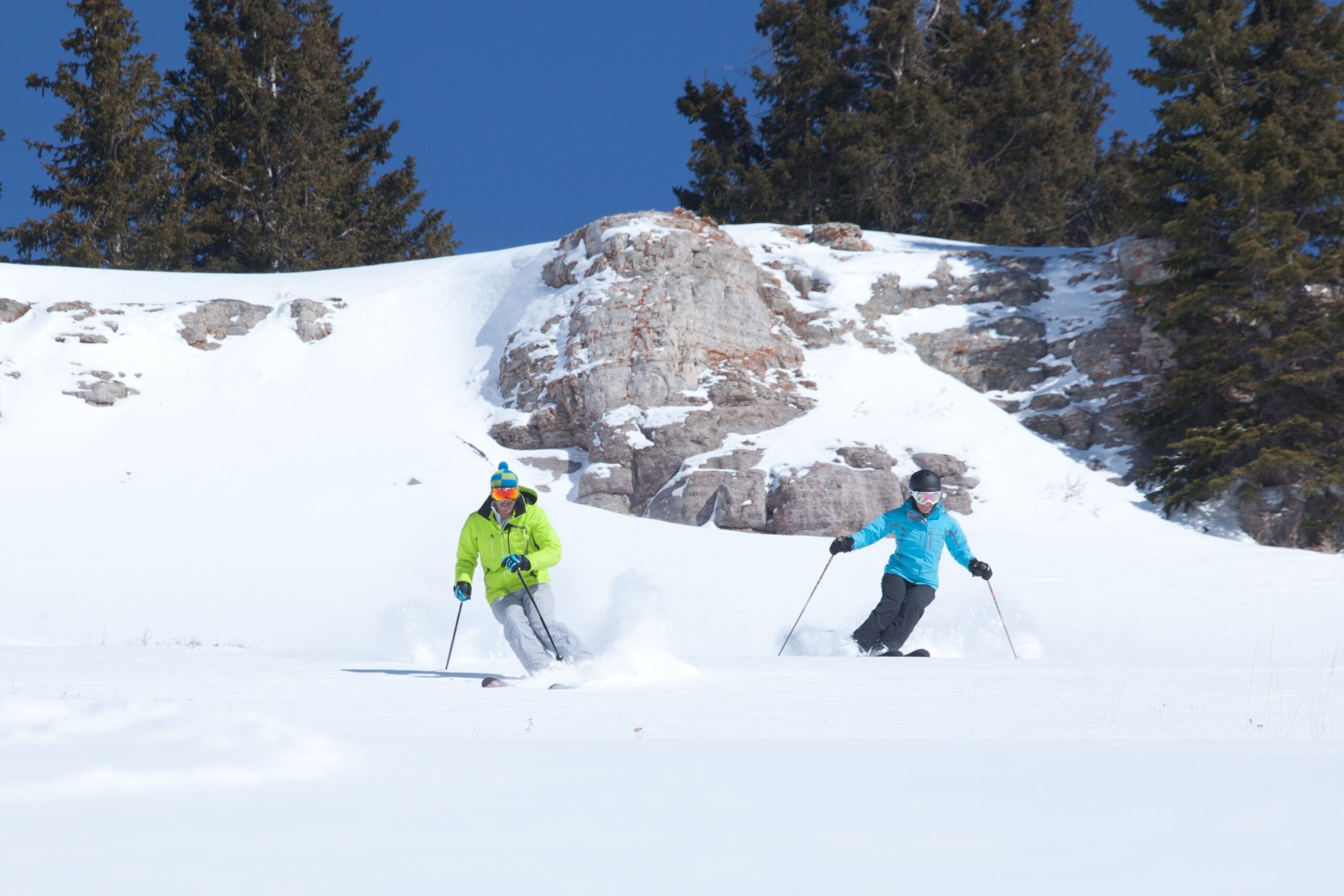 two people in brightly colored jackets skiing in Vail