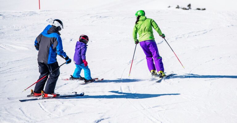 A family skiing together down a snowy slope, enjoying a winter day in the mountains