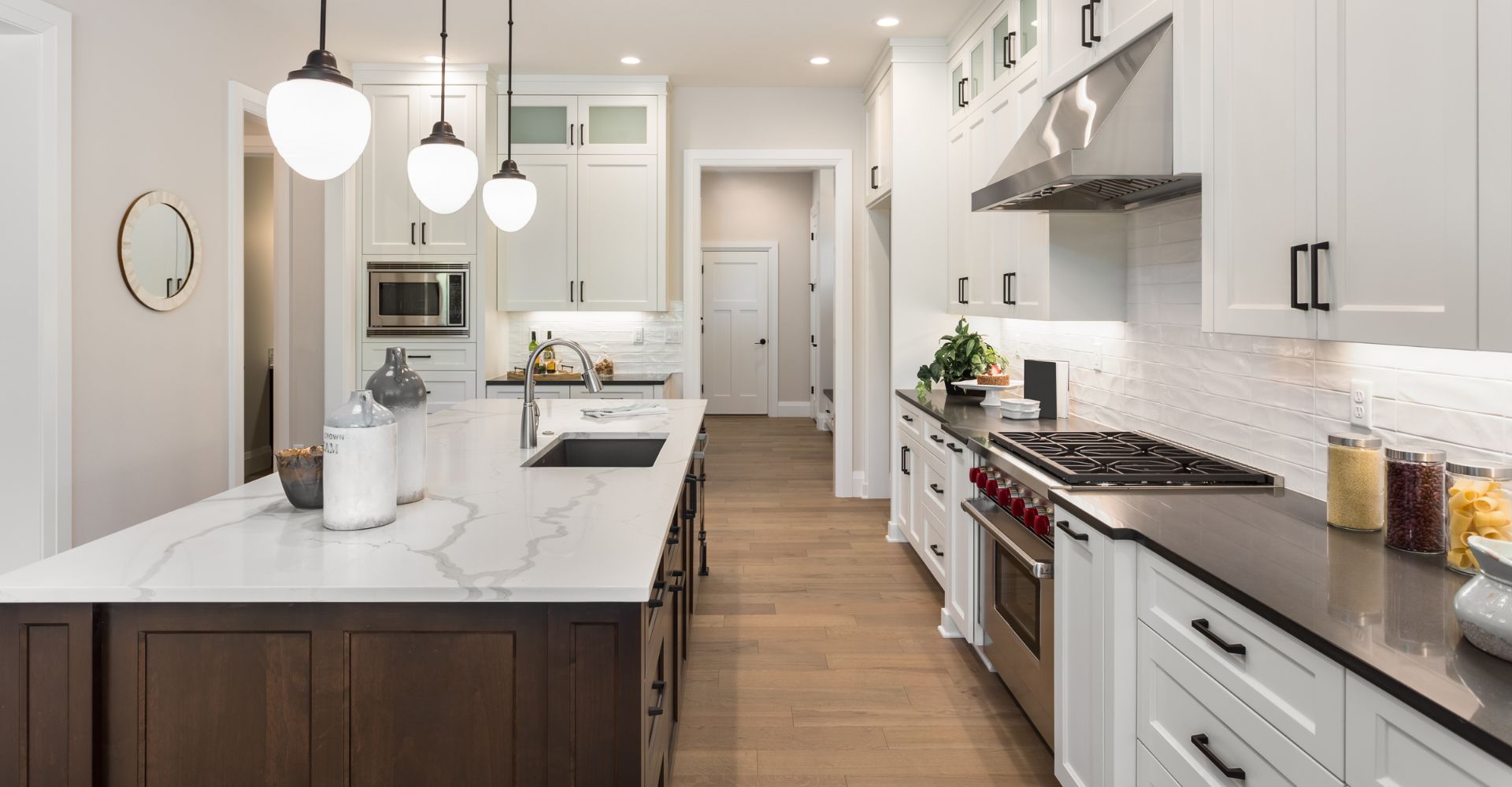 A modern kitchen featuring white cabinets and warm wood floors, creating a bright and inviting atmosphere